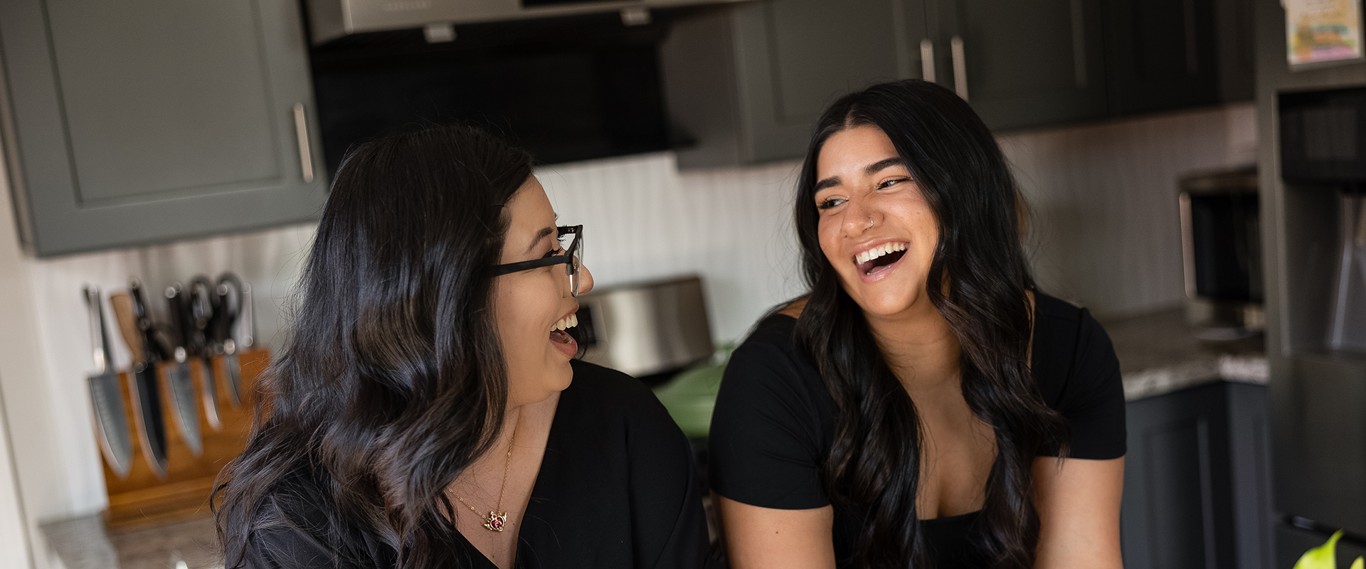 Two women laughing at a kitchen counter