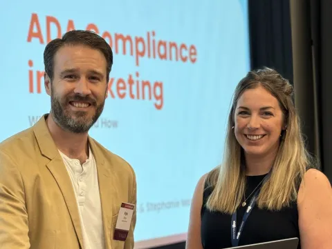 Kyle Brice and Stephanie Mazza smiling at their presentation titled "ADA Compliance in Marketing: What, Why and How"